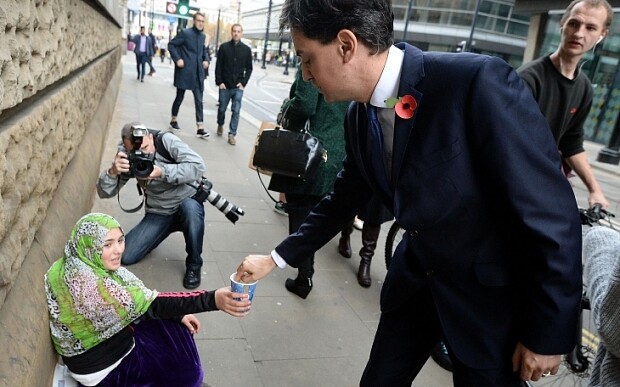 Ed Miliband Faces A Fight To Save Its Scottish MPs...MANCHESTER, ENGLAND - OCTOBER 31: Labour leader Ed Miliband donates money to a woman as he walks to a meeting with UK council leaders at the Town Hall on October 31, 2014 in Manchester, England. A recent poll has predicted that Labour could lose it's Scottish seats to the Scottish National party next year. (Photo by Nigel Roddis/Getty Images)